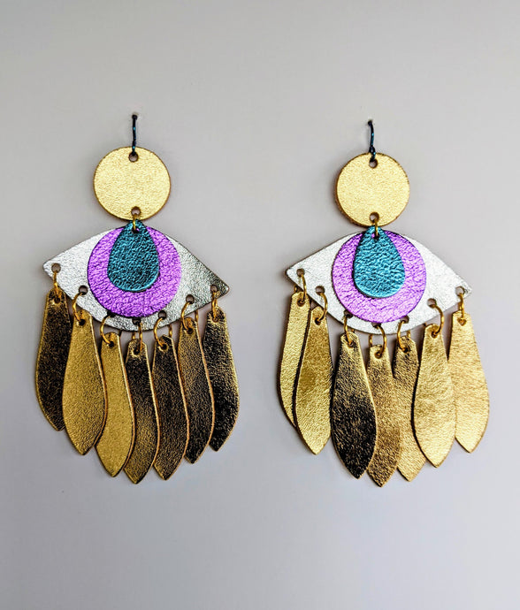 Statement earrings in the shape of eyes made from silver and gold leather. 